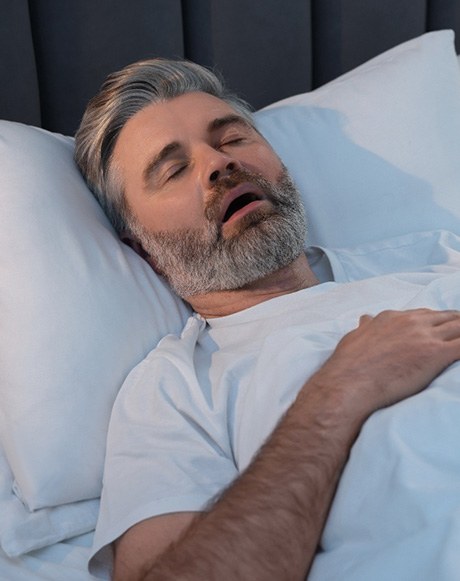 Bearded man lying in bed and snoring