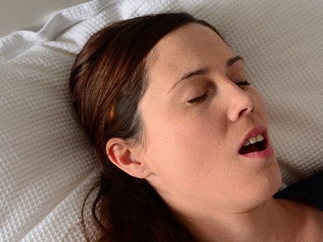 Close-up of woman snoring in bed