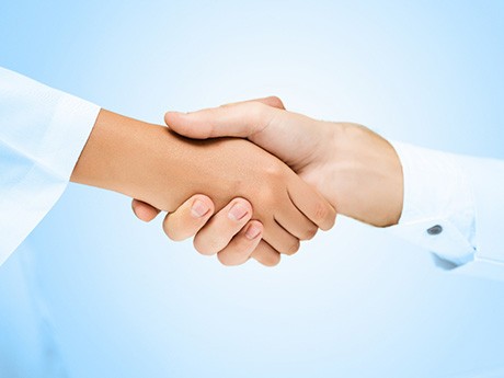 Close-up of patient shaking hands with dentist