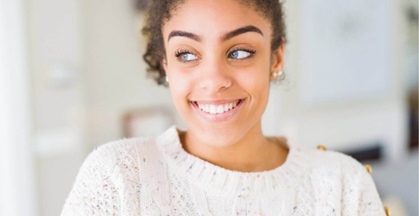 Woman in a sweater standing and smiling