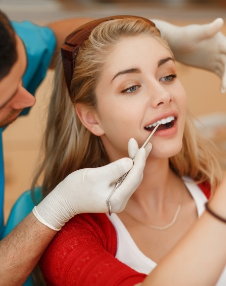 Dentist looking at dental patient's smile after cosmetic dental bonding
