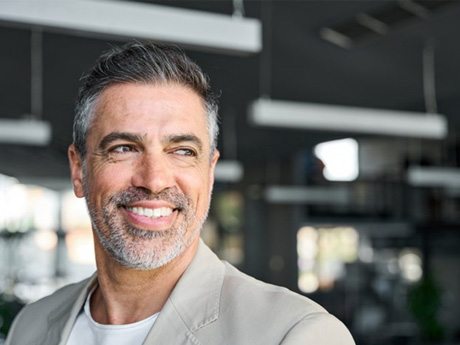 a man with dentures smiling in an office 