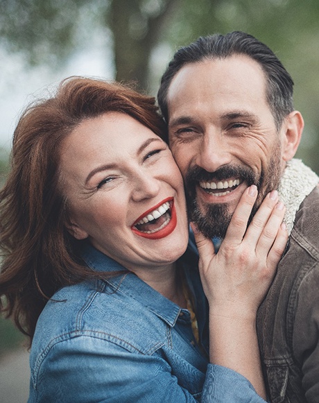 couple smiling after getting dental implants in Marysville