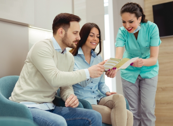 Dental team member and patients discussing financing options