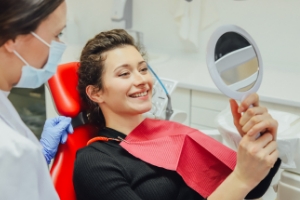 Woman looking at her smile after dental treatment