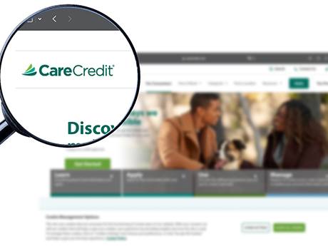 a magnifying glass zooming in on a CareCredit logo