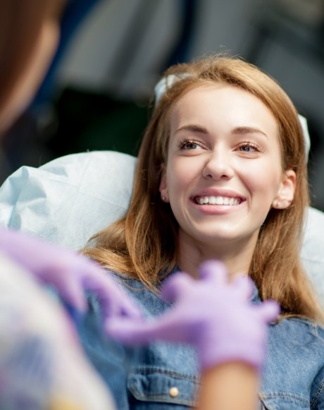 Woman smiling at dentist after tooth colored filling treatment