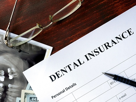 Top of dental insurance form with glasses and pen