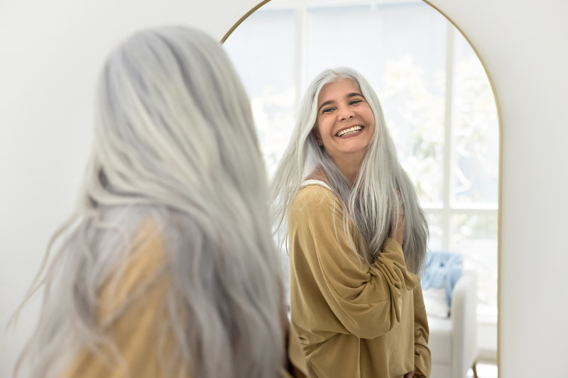 Patient smiling in the mirror after BOTOX treatment